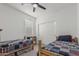 This bedroom features two twin beds with decorative quilts, closet with bi-fold doors, and a ceiling fan at 2923 W Shanley Ave, Apache Junction, AZ 85120