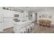 Bright kitchen featuring white cabinets, marble countertops, and a spacious central island with bar seating at 2923 W Shanley Ave, Apache Junction, AZ 85120