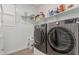 Functional laundry room featuring modern appliances, built-in shelving, and sleek tile flooring for convenient household tasks at 2923 W Shanley Ave, Apache Junction, AZ 85120