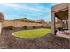 Landscaped backyard with a small lawn, mature trees, and a covered patio at 3022 W Redwood Ln, Phoenix, AZ 85045