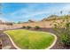Well-maintained backyard with a tidy lawn, desert landscaping, and block wall at 3022 W Redwood Ln, Phoenix, AZ 85045
