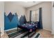 This bedroom has a blue accent wall and bedding, a ceiling fan, and tile flooring at 3022 W Redwood Ln, Phoenix, AZ 85045