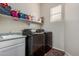This is the laundry room with black front load washer and dryer, sink, and storage shelf at 3022 W Redwood Ln, Phoenix, AZ 85045