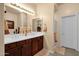 Bright bathroom with dual sinks, wood cabinets, a walk-in shower and separate door at 3131 E Legacy Dr # 1057, Phoenix, AZ 85042