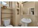 Half bathroom featuring neutral decor, toilet, pedestal sink and small shelving unit at 3131 E Legacy Dr # 1057, Phoenix, AZ 85042