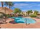 Resort-style pool with lounge chairs, umbrellas, and lush landscaping surrounded by the community buildings at 3131 E Legacy Dr # 1057, Phoenix, AZ 85042