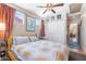 Inviting bedroom showcasing a decorative ceiling fan, closet, and comfortable bed with sun-patterned linens at 3243 E Sheridan St, Phoenix, AZ 85008
