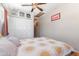 Bright bedroom featuring a ceiling fan, artwork, and a comfortable bed with sun-patterned linens at 3243 E Sheridan St, Phoenix, AZ 85008