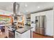 Kitchen features a stainless-steel refrigerator, white cabinetry, and island cooktop at 3243 E Sheridan St, Phoenix, AZ 85008