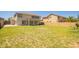 A spacious backyard with healthy green grass showcases a tan two-story home with covered patio at 34949 N Spur Cir, San Tan Valley, AZ 85144