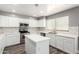 Well-equipped kitchen with island, modern appliances, white cabinets, and ample natural light at 34949 N Spur Cir, San Tan Valley, AZ 85144