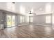 Bright living room featuring wood-look tile flooring, neutral walls, and a sliding glass door at 34949 N Spur Cir, San Tan Valley, AZ 85144