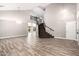 Bright living room showcasing wood-look tile flooring, a staircase, and soaring ceilings at 34949 N Spur Cir, San Tan Valley, AZ 85144