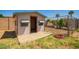 Small wooden shed with colorful awning and open doorway in a grassy backyard with chain link fence and hose at 34949 N Spur Cir, San Tan Valley, AZ 85144