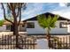Charming home with white brick, black trim, desert landscaping, and a wrought iron fence at 3802 N 48Th Dr, Phoenix, AZ 85031