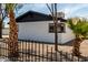 Exterior view with palm trees and desert landscaping framed by black wrought iron fence at 3802 N 48Th Dr, Phoenix, AZ 85031
