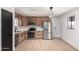 Modern kitchen featuring stainless appliances, wooden cabinets, and wood laminate flooring at 3802 N 48Th Dr, Phoenix, AZ 85031