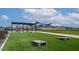 Community play area featuring a covered picnic spot, cornhole, and a large grass play area at 3808 S Buttercup --, Mesa, AZ 85212
