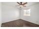 Bright bedroom features modern wood-look tile flooring and a ceiling fan with a window bringing in natural light at 4636 W Mission Ln, Glendale, AZ 85302