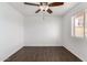 Bright bedroom features modern wood-look tile flooring and a ceiling fan with a window bringing in natural light at 4636 W Mission Ln, Glendale, AZ 85302
