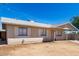 Side view of a single-story home featuring an open front yard under a clear blue sky at 4636 W Mission Ln, Glendale, AZ 85302