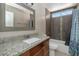 Bathroom showcasing vanity with granite counters, tiled shower and tub, toilet and mirror at 4813 W Belmont Ave, Glendale, AZ 85301
