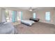 Spacious bedroom with large windows, neutral walls and carpet, ceiling fan and multiple beds at 4813 W Belmont Ave, Glendale, AZ 85301