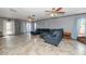 Large living area featuring tile flooring, a comfortable sectional sofa, and access to the backyard through glass doors at 4813 W Belmont Ave, Glendale, AZ 85301