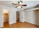 Bedroom with wood-look floors, ceiling fan, crown molding, closet, and view into another room at 4850 E Desert Cove Ave # 240, Scottsdale, AZ 85254