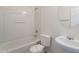 Clean, all white bathroom with tub shower combo, toilet, and pedestal sink at 5628 S 21St Pl, Phoenix, AZ 85040