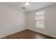 Empty bedroom with wood floors and view of tile roofs through window at 5628 S 21St Pl, Phoenix, AZ 85040