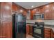 Kitchen with wood cabinets and black appliances including range, microwave and fridge at 5628 S 21St Pl, Phoenix, AZ 85040