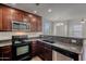 Kitchen with wood cabinets and black appliances including range, microwave, and dishwasher at 5628 S 21St Pl, Phoenix, AZ 85040