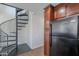 View of kitchen wood cabinets and black fridge, plus view of spiral staircase at 5628 S 21St Pl, Phoenix, AZ 85040