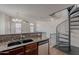 Kitchen featuring bar-height granite counters, wood cabinets, and view of spiral staircase at 5628 S 21St Pl, Phoenix, AZ 85040