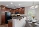 Cozy kitchen featuring granite countertops, dark wood cabinetry, and modern appliances adjacent to dining space at 5628 S 21St Pl, Phoenix, AZ 85040
