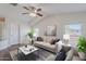 Bright living room featuring a ceiling fan, plush seating, and elegant decor with light streaming through the windows at 5628 S 21St Pl, Phoenix, AZ 85040
