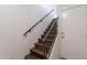 A modern staircase with hardwood steps and a sleek metal railing leads to the next floor at 5628 S 21St Pl, Phoenix, AZ 85040