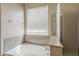 Bright bathroom featuring a soaking tub, granite countertop, and shower with glass enclosure at 5926 W Questa Dr, Glendale, AZ 85310