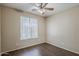 Bedroom with hardwood floors, a ceiling fan, and a window with horizontal blinds at 5926 W Questa Dr, Glendale, AZ 85310