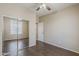 Bedroom featuring ceiling fan, wood floors, and a mirrored closet, offering ample storage at 5926 W Questa Dr, Glendale, AZ 85310