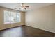 Bright bedroom featuring a ceiling fan, large window, and dark wood-look floors at 5926 W Questa Dr, Glendale, AZ 85310