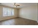 Bright bedroom featuring a ceiling fan, neutral paint, large window, and tile floors at 5926 W Questa Dr, Glendale, AZ 85310