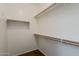 Walk-in closet with wooden shelves and ample storage space; floor is laminate at 5926 W Questa Dr, Glendale, AZ 85310