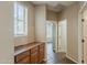 Hallway with ceramic floors and wooden cabinet; view of room with ceiling fan and window at 5926 W Questa Dr, Glendale, AZ 85310