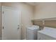 Laundry room with white appliances, storage shelf, and a door to access the rest of the home at 5926 W Questa Dr, Glendale, AZ 85310