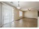 Spacious living room with sliding door, tile flooring, and modern light fixture at 5926 W Questa Dr, Glendale, AZ 85310