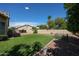 Expansive backyard with artificial turf, gravel landscaping, mature trees, and a fenced-in area, perfect for recreation and relaxation at 6135 E Aire Libre Ln, Scottsdale, AZ 85254