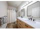 This remodeled bathroom features a double sink, framed mirrors, tile floor and shower with decorative curtain at 6135 E Aire Libre Ln, Scottsdale, AZ 85254