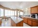 Well-lit kitchen with a large center island, wood cabinetry, tile floors, and plenty of natural light at 6135 E Aire Libre Ln, Scottsdale, AZ 85254